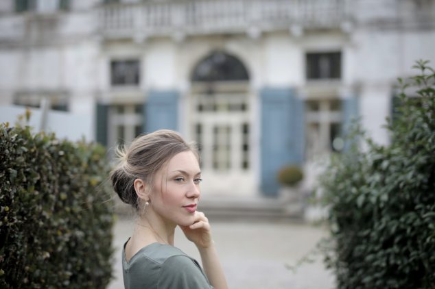 pensive-woman-on-background-of-old-palace-among-plants-3831034
